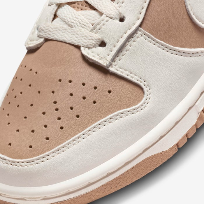 Detaliu picior pantof Nike Dunk Low Next Nature Sail Brown cu perforații și șireturi albe