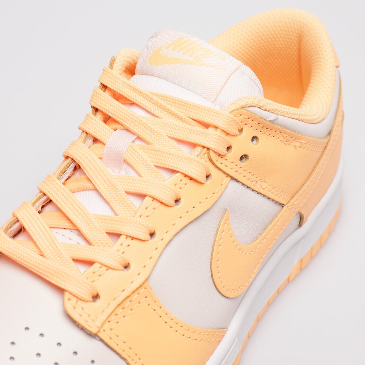 Pantofi Nike Dunk Low Peach Cream cu șireturi și detalii portocalii pe fundal alb