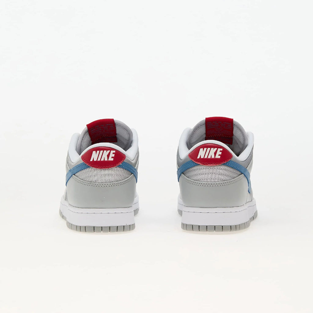 Pantofi sport Nike Dunk Low QS Metallic Silver Aegean Storm văzuți din spate cu detalii albastre și logo roșu Nike