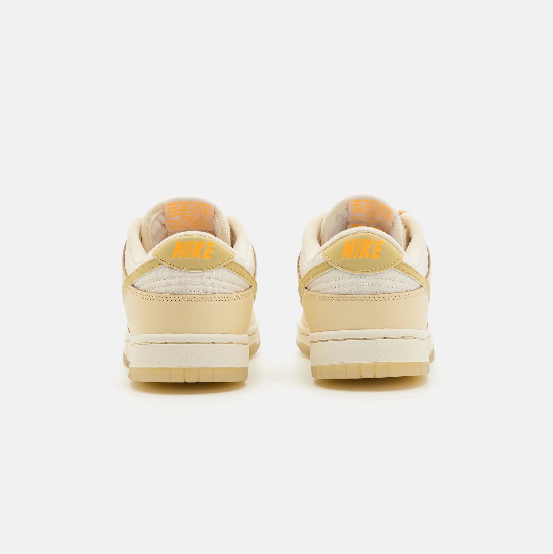 Pantofi Nike Dunk Low Muslin Team Gold, vedere din spate cu logo galben și detalii crem
