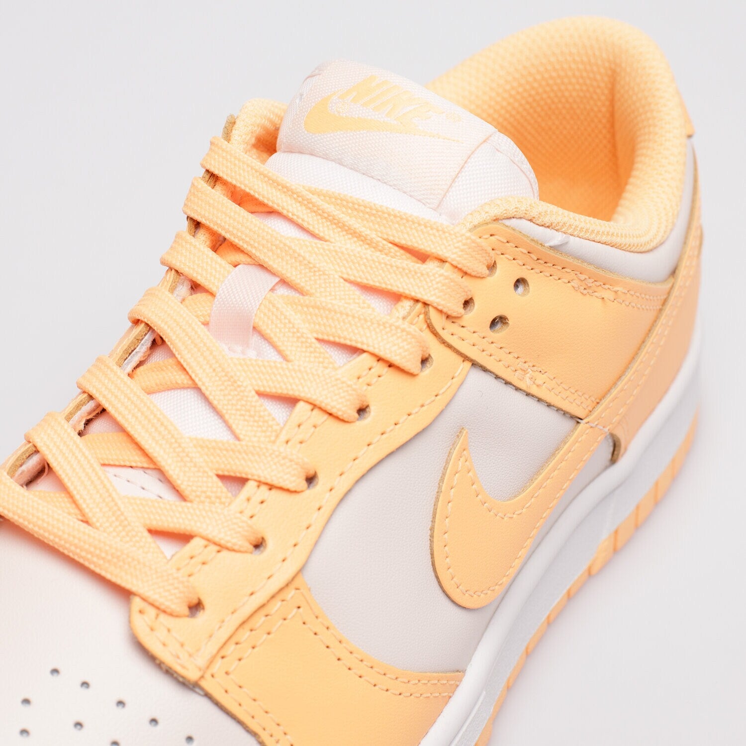 Pantofi Nike Dunk Low Peach Cream cu șireturi și detalii portocalii pe fundal alb